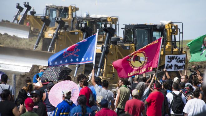 Члены племени Стоящая скала сиу и их сторонники, выступающие против трубопровода доступа Дакота, противостоят бульдозерам, работающим на площадке, 3 сентября 2016 года