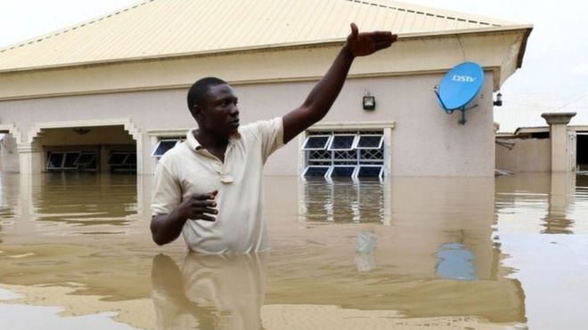 A man gestures next to his flooded house following heavy rain near the Nigerian town of Lokoja, in Kogi State, on September 14, 2018.