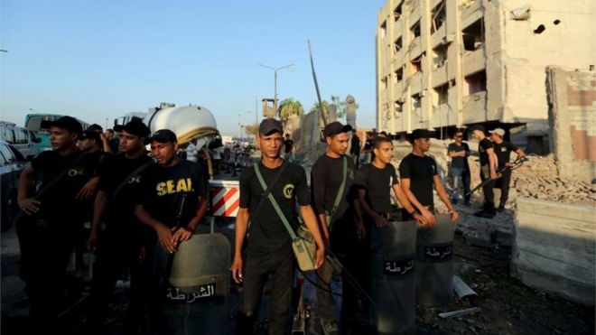 Египетские силы безопасности возле здания, поврежденного бомбами, в Каире (август 2015 года)