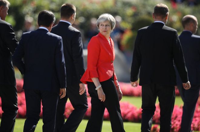 Theresa May departs from a meeting in Salzburg