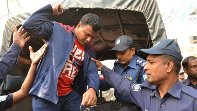 28 февраля 2017 года полиция Бангладеш сопровождает осужденного исламистского боевика возле здания суда в Рангпуре после вынесения смертного приговора в связи с убийством японского гражданина в 2015 году.