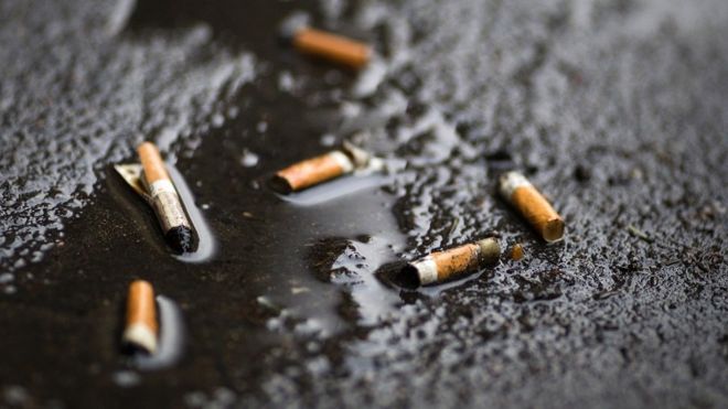 Сигаретные окурки видны в канаве в январе 2012 года в Париже