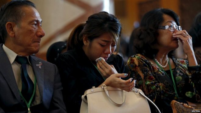 Родственники Нг Цин Чжэна, который был убит на борту рейса MH17 Malaysia Airlines, плачут на поминальной службе 11 июля