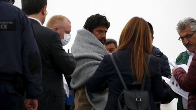 A deportee is escorted aboard the ferry on Lesbos, 8 April