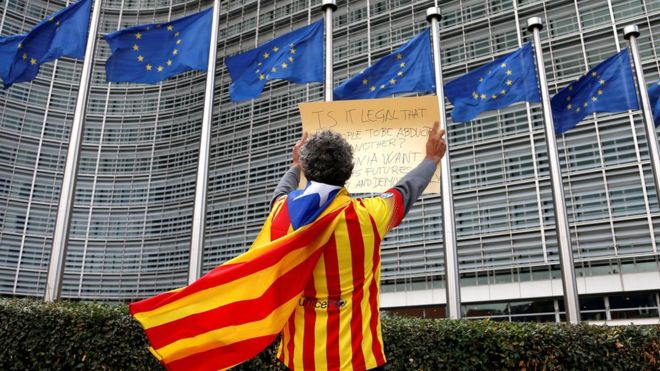 A man draped in a Catalan independence flag protests outside the European Commission in Brussels, 2 October