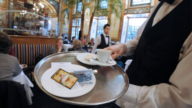 Официант приносит кофе и счет клиентам в ресторане в Нант