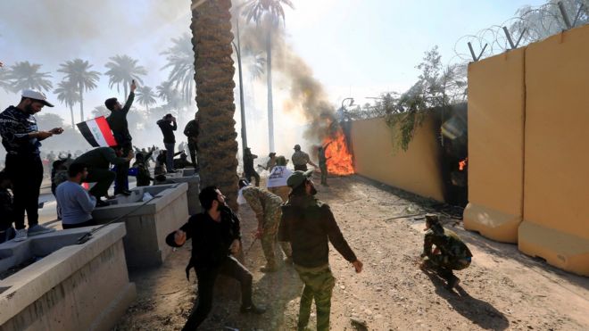 Protesters set fire to the wall of the US embassy compound in Baghdad, Iraq (31 December 2019)