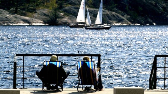 Шведская пара на шезлонгах с видом на море в Швеции