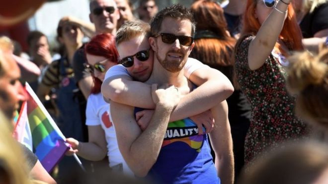 Two men embrace at a celebration in Sydney