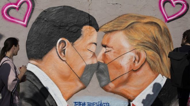 前柏林墙的街头艺术画，画面显示美国总统特朗普和中国国家主席习近平戴着防护口罩在接吻。