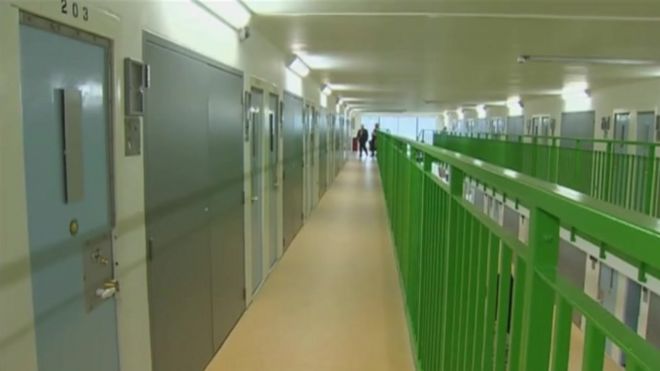 Тюремное крыло HMP Berwyn показывает длинный коридор с закрытыми дверями камеры