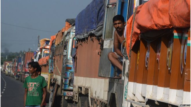 Индийский водитель грузовика смотрит из припаркованного грузовика, перевозящего грузы в Непал, недалеко от границы между Индией и Непалом в Панитанки, примерно в 40 км от Силигура