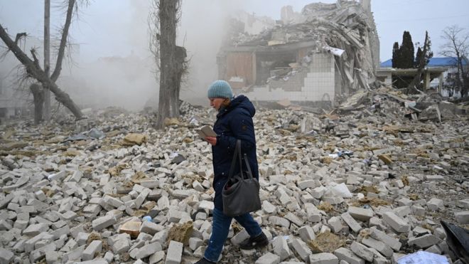 Жеещина у развалин дома