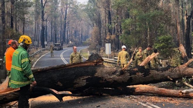 Firefighters clearing a road