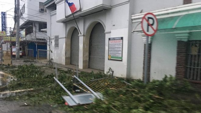 Ветви, унесенные через улицы в Tuguegarao