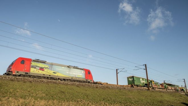 На изображении изображен товарный поезд с видимым большим зазором в ширину одного грузового вагона