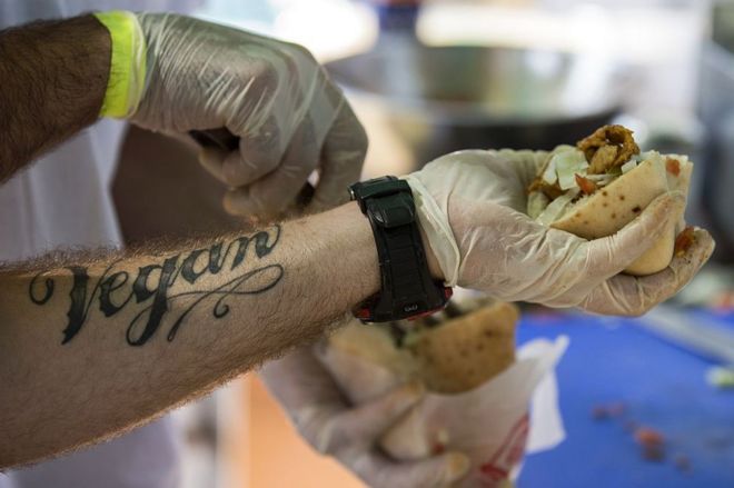 Человек с вегетарианской татуировкой, где подают еду