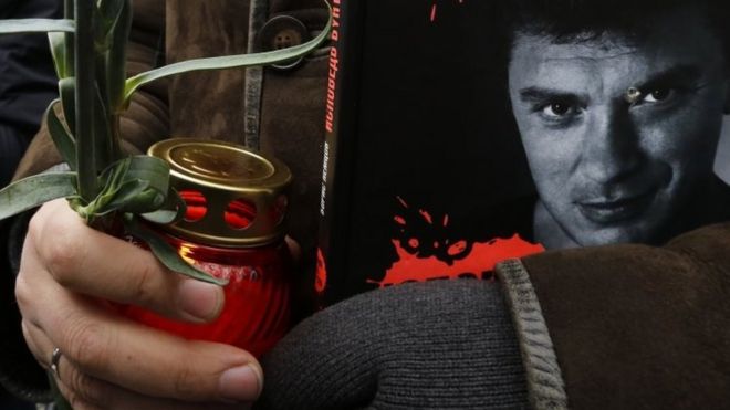 Скорбящий держит свечу с фотографией Бориса Немцова в Москве. Фото: март 2015