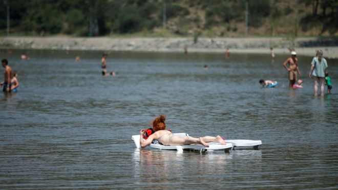 Женщина загорает в водах озера Лиси в жаркий летний день в Тбилиси, Грузия, 10 июля 2018 года