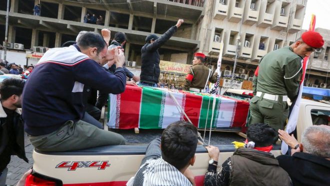 Mourners surround a car carrying the coffin of Iranian military commander Qasem Soleimani