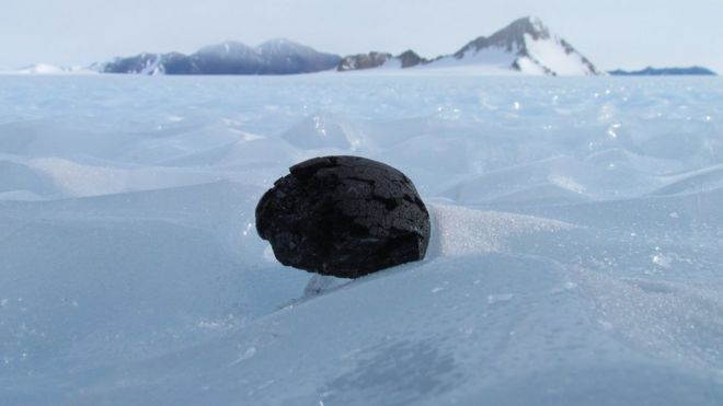 метеорит, сидящий на льду в Антарктиде
