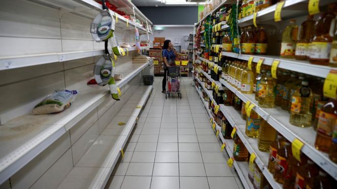 Пакет риса изображен на пустой полке, когда люди запасаются продуктами питания после того, как Сингапур поднял уровень предупреждения о вспышке коронавируса до оранжевого в супермаркете в Сингапуре 8 февраля 2020 г.