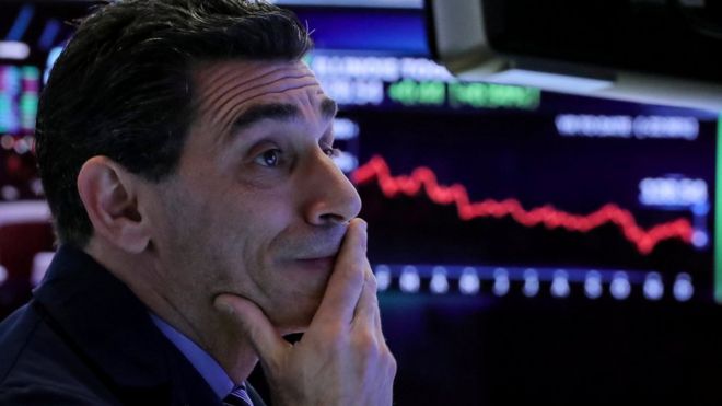 Трейдер работает на своем посту на полу Нью-Йоркской фондовой биржи