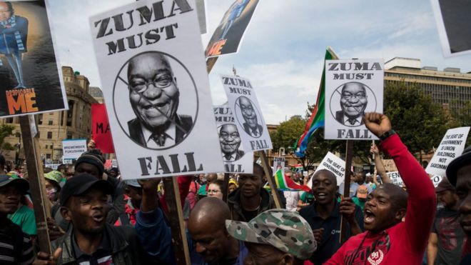 Protest of people wey dey hold sign wey talk say "Zuma must Fall" and "Despicable Me"