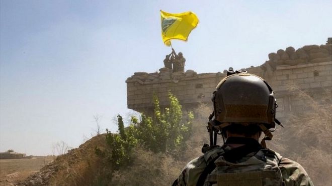 Военный и флаг "Демократических сил Сирии"