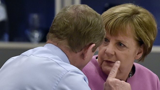 Премьер-министр Ирландии Энда Кенни (слева) беседует с канцлером Германии Ангелой Меркель (справа) во время ужина глав государств Европейского союза (ЕС) во время саммита ЕС в Брюсселе 19 февраля 2016 года.