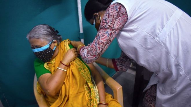 A woman receives a dose of COVISHIELD, a coronavirus disease (COVID-19) vaccine at a Kolkata Municipality medical centre in Kolkata.