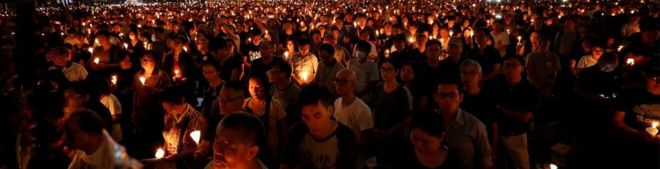 Люди присутствуют на бдении при свечах в парке Виктория в Гонконге