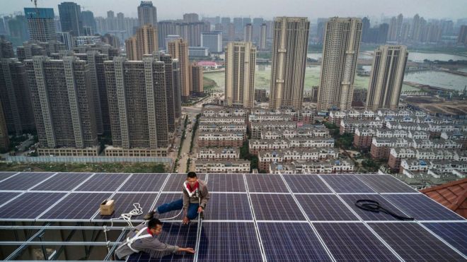 Мужчины работают над проектом солнечных панелей в Ухане, Китай.