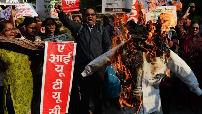 Индийские активисты выкрикивают лозунги во время акции протеста, когда они сжигают чучело главного министра Харьяны Манохар Лал Хаттар в Нью-Дели 17 января 2018 года против группового изнасилования двух школьниц в соседнем штате Харьяна.