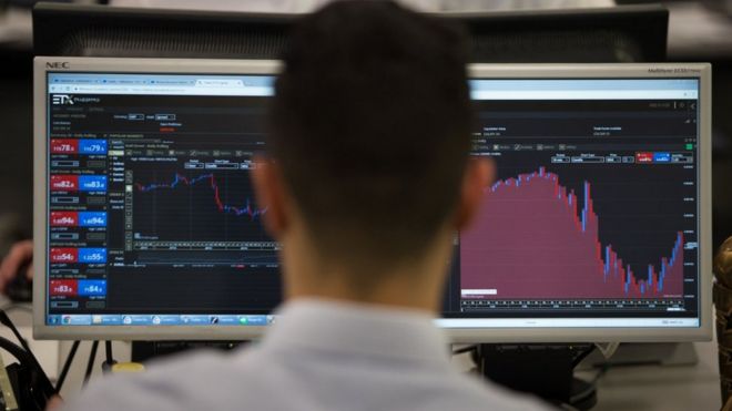 Trader looks at stock market screens