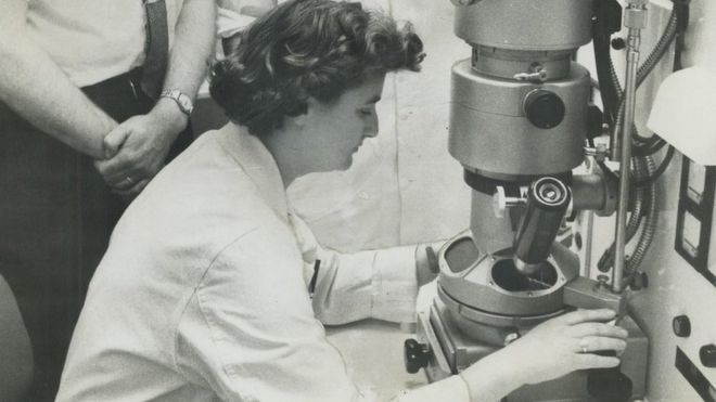 June Almeida como seu microscópio eletrônico em 1963, no Canadá