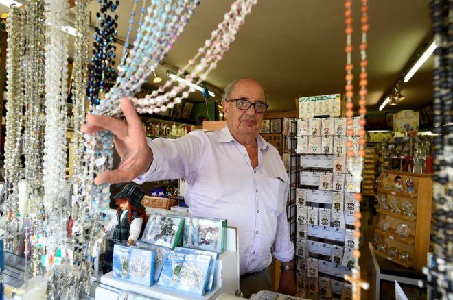 Лавочник Берни Бирн, 74 года, отодвигает четки, которые он продает в своем магазине
