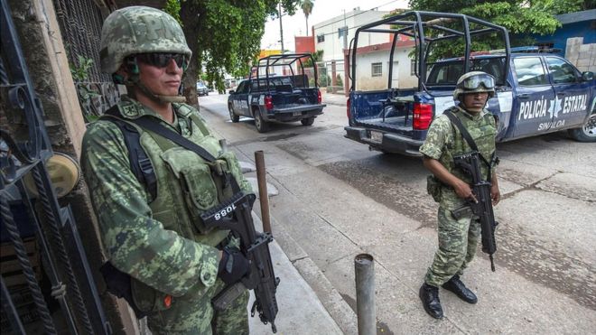 Soldados al lado de vehículos de la policía en México.