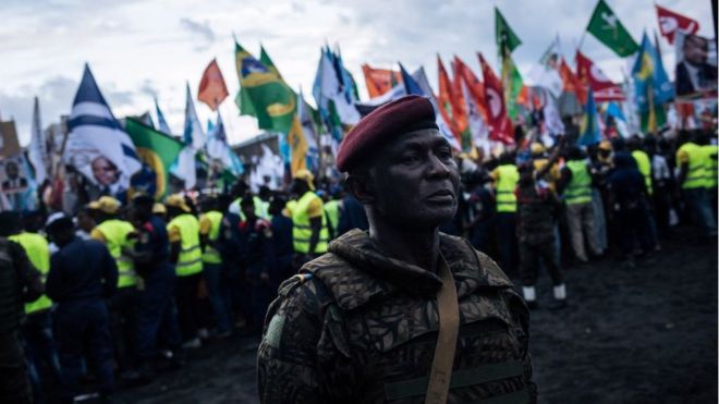 Военнослужащий стоит перед толпой во время митинга кандидата в президенты Эммануила Рамазани Шадары в Гоме, Северная Киву, 16 декабря 2018 года