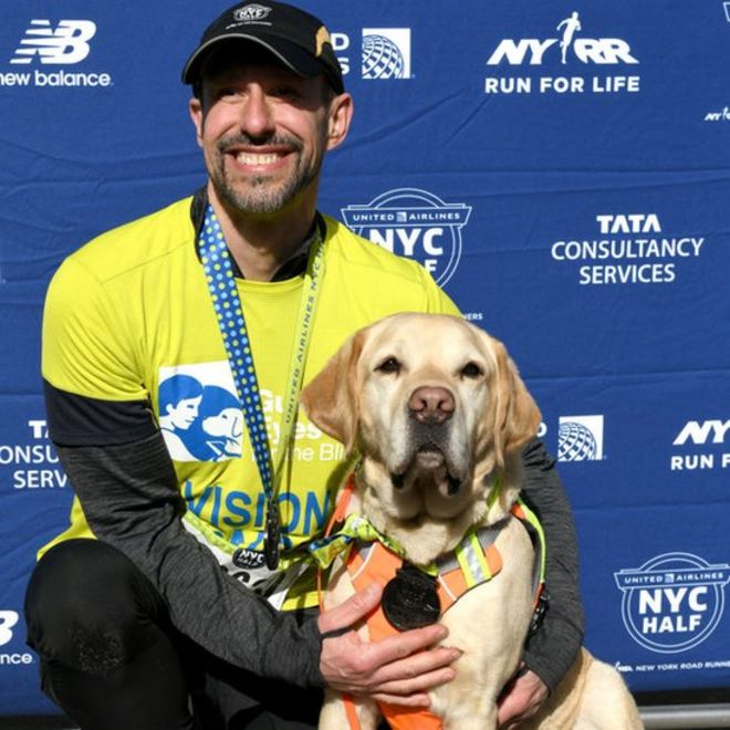 Томас Панек после пробежки полумарафона в Нью-Йорке со своей собакой-поводырем Гасом