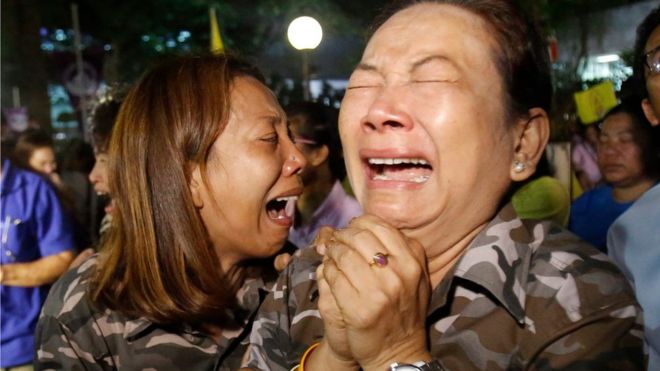 Люди плачут после объявления Королевского дворца возле больницы Сирираджа, где проходил лечение тайский король Пумипон Адульядей, в Бангкоке, Таиланд, в четверг, 13 октября 2016 года.