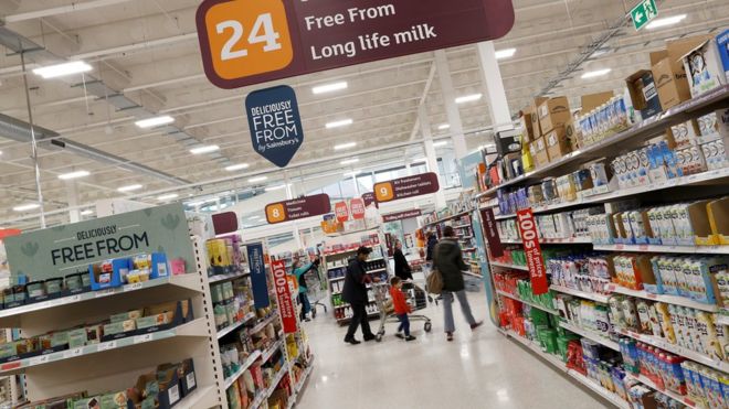 Длинный молочный проход в слиянии Sainsbury's-Asda