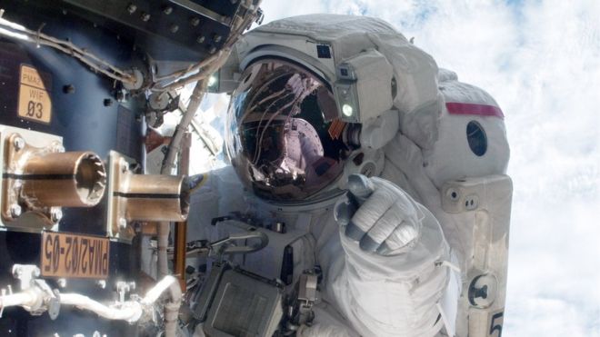 NASA astronaut Mike Fossum carries out maintenance during a space walk at the International Space Station