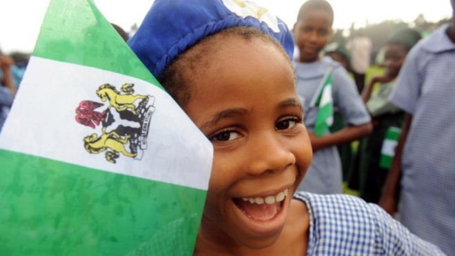 Нигерийская студентка улыбается, присутствуя на праздновании Дня независимости в Лагосе 1 октября 2013 г.