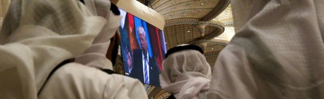 Чайные серверы наблюдают за тем, как президент США Дональд Трамп выступает с речью на арабском исламском американском саммите