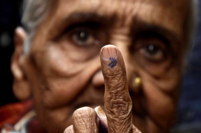 Индийская женщина показывает свой отпечатанный чернилами палец после того, как проголосовала на избирательном участке для выборов в государственное собрание штата Мадхья-Прадеш в Бхопале, Индия, 28 ноября 2018 года