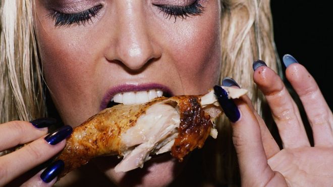 mujer comiendo pollo
