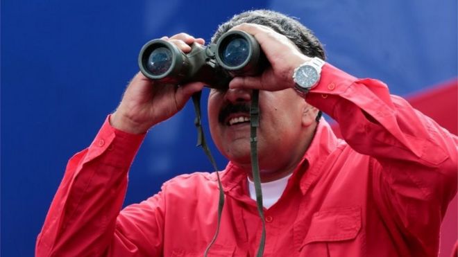 Президент Венесуэлы Николас Мадуро использует бинокль во время митинга в Каракасе, Венесуэла, 19 апреля 2017 года.