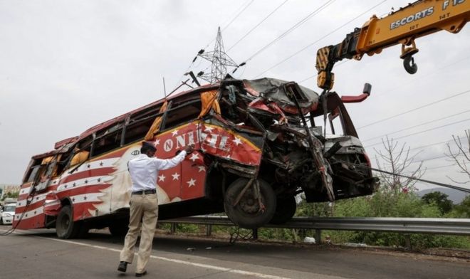 Кран вывозит поврежденный автобус с места происшествия на автостраде Мумбаи - Пуна близ Панвела, на окраине Мумбая, Индия, 05 июня 2016 г.