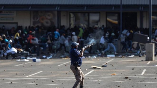 Un miembro de la policía de Sudáfrica dispara balas de goma contra un grupo que saqueó el centro comercial Jabulani en Soweto, al suroeste de Johannesburgo, el 12 de julio de 2021.